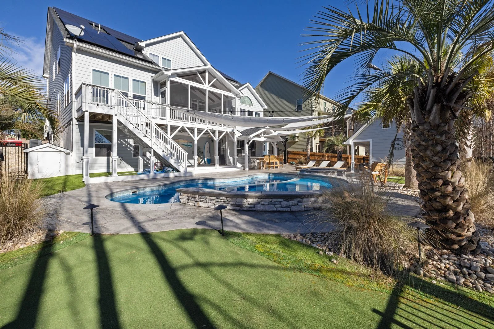 Poolside outdoor living area with palm trees